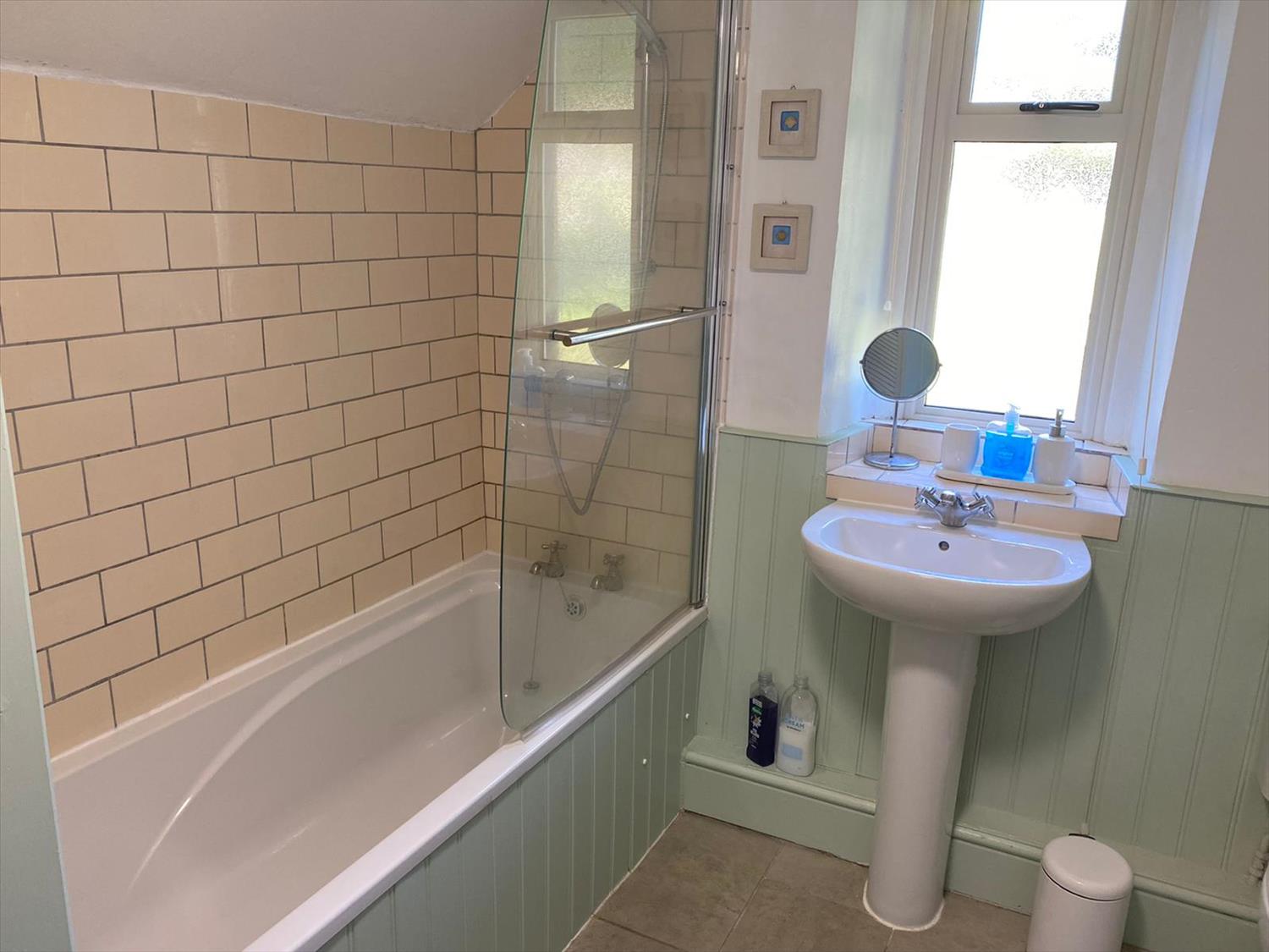 Newly refurbished  bathroom with shower above bath. There is an electric heated towel rail.