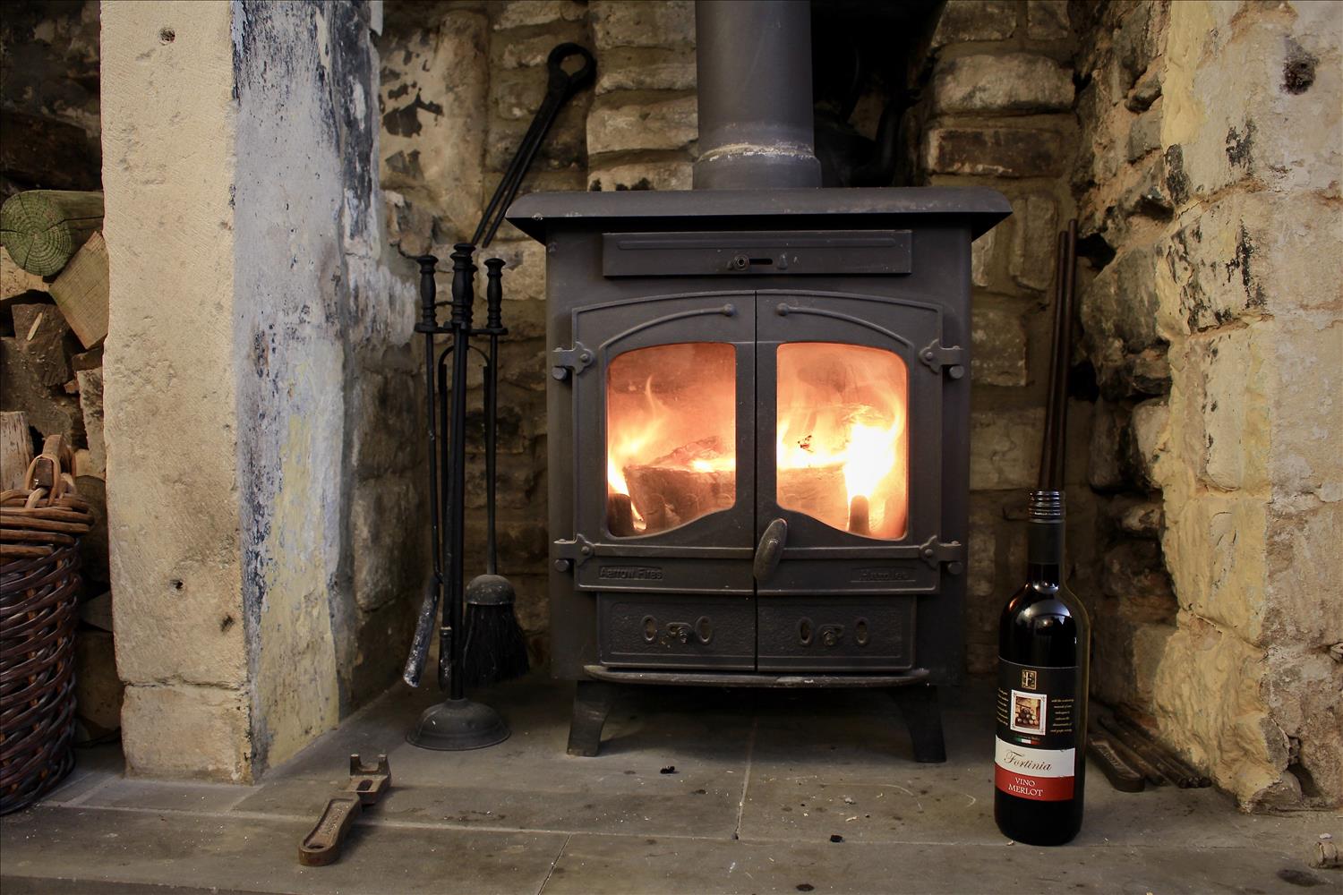 Log burner with lovely bottle of red wine